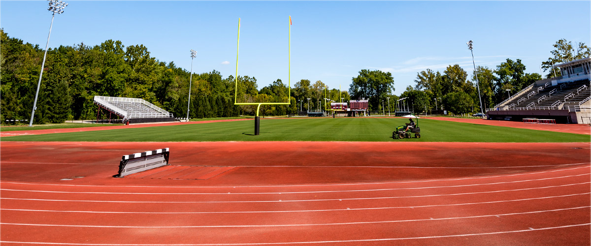 Image shows Phil Brown field as seen from the SRC. In the distance a person can be seen mowing the grass of the field.