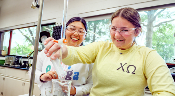 Two female students work in chemical engineering lab.