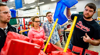 Students work on a device designed to help disabled children stand.