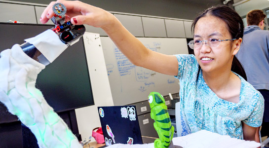 !Students demonstrate specialized toy for developing motorskills