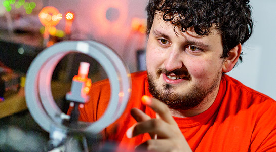 !Male student working with optical engineering equipment in a Rose-Hulman lab.