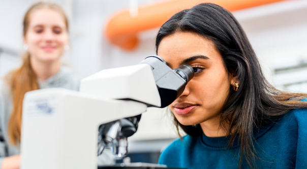 A student and professor examine the results of an experiment in a biology laboratory. 