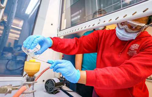 A female student works on an experiment in a chemistry lab.