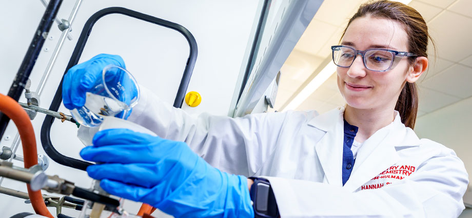 A female student performs an experiment in chemistry lab.