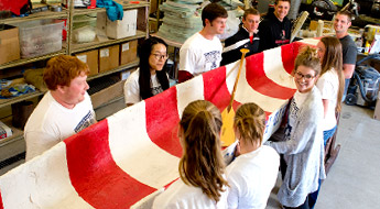 Students gather around concrete canoe.