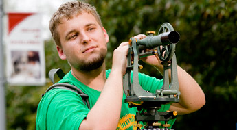 Student works with piece of equipment outside.