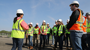 Rose-Hulman civil engineering students listen to speaker outside.