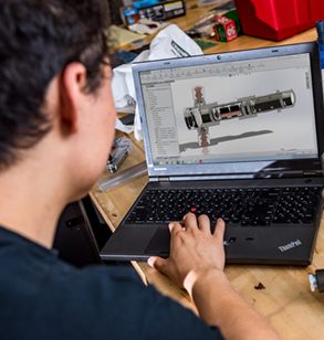 Engineer designing a device on a laptop computer.