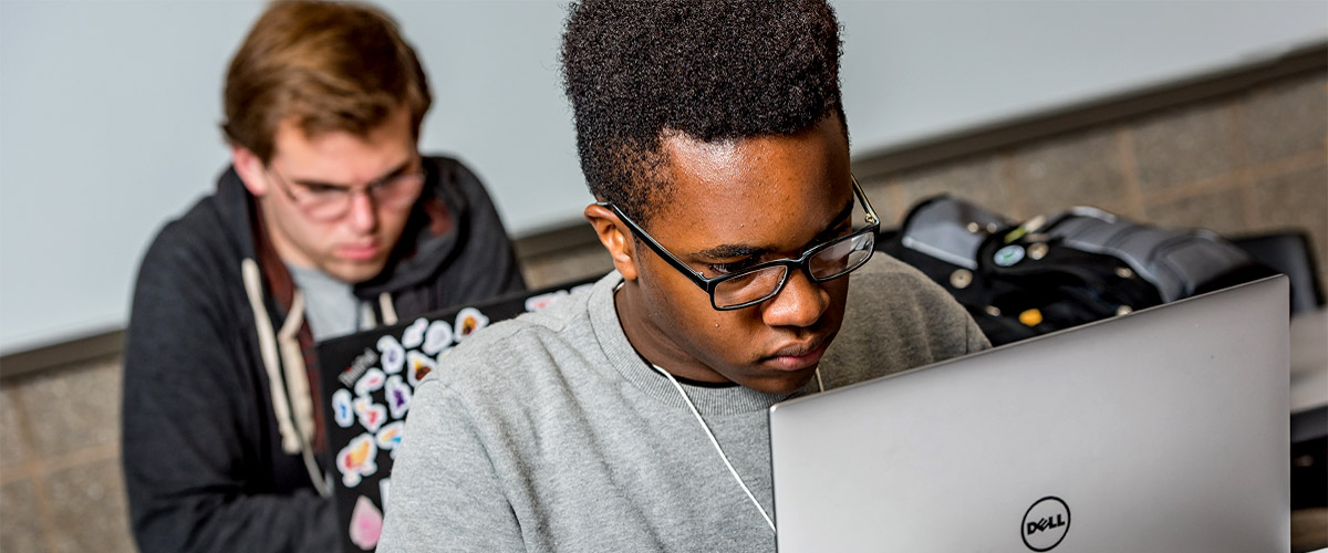 Male student working on a laptop.