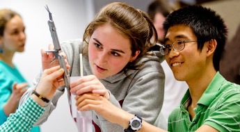 A female and a male student work together in a hands-on activity.