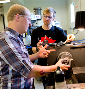 Students using shop equipment for project.