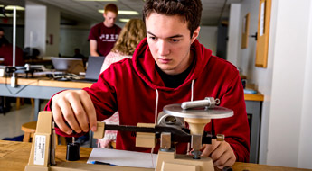 Male student uses scale to weigh item.