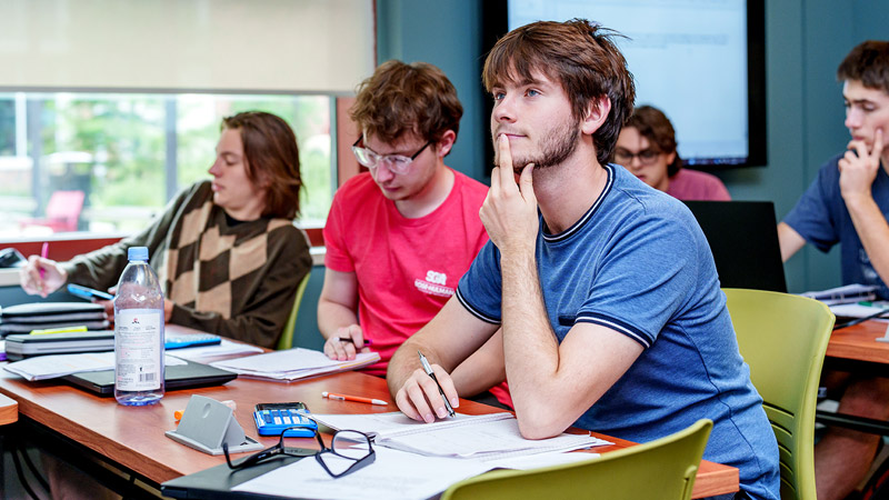 Two male students work together in classroom.