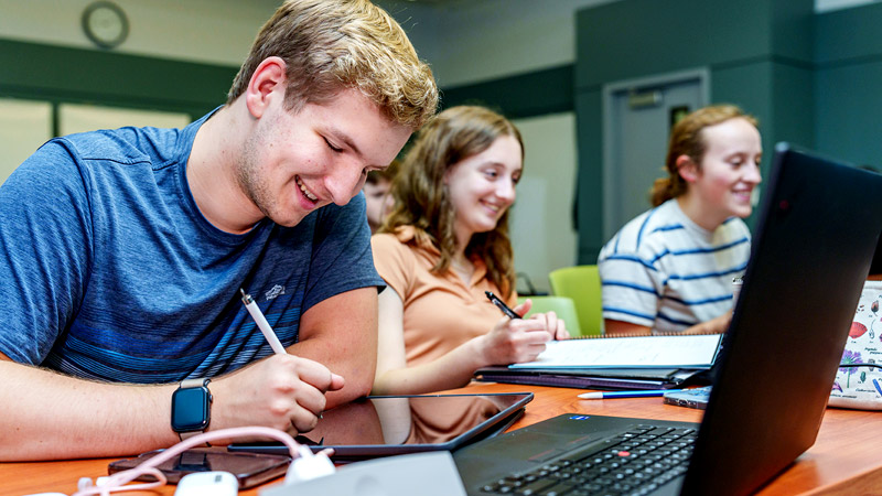 Male student and female student use a scale in a physics lab