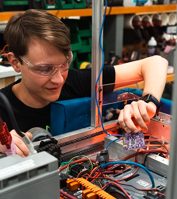 Student wires a tall robot.