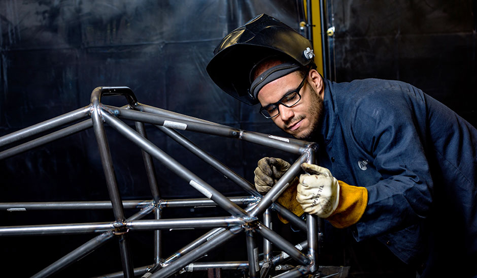 Student welding car frame