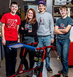 Project team poses with assistive device they developed for a client.