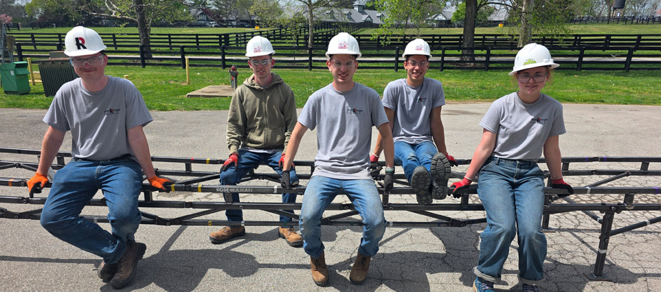 Five students perch atop their steel bridge project.