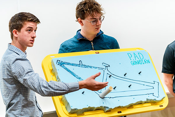 Two students pitch a device they designed during the Engineerathon event.