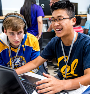 Laughing male students using laptop computer.