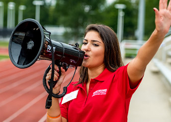 !Female in RHIT shirt with a bullhorn