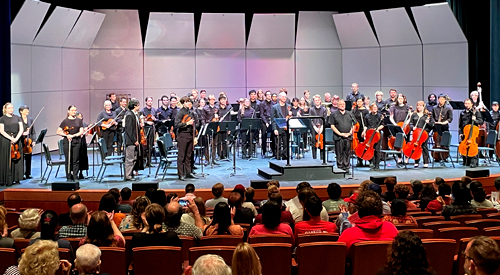 !Students performing on musical instruments on stage