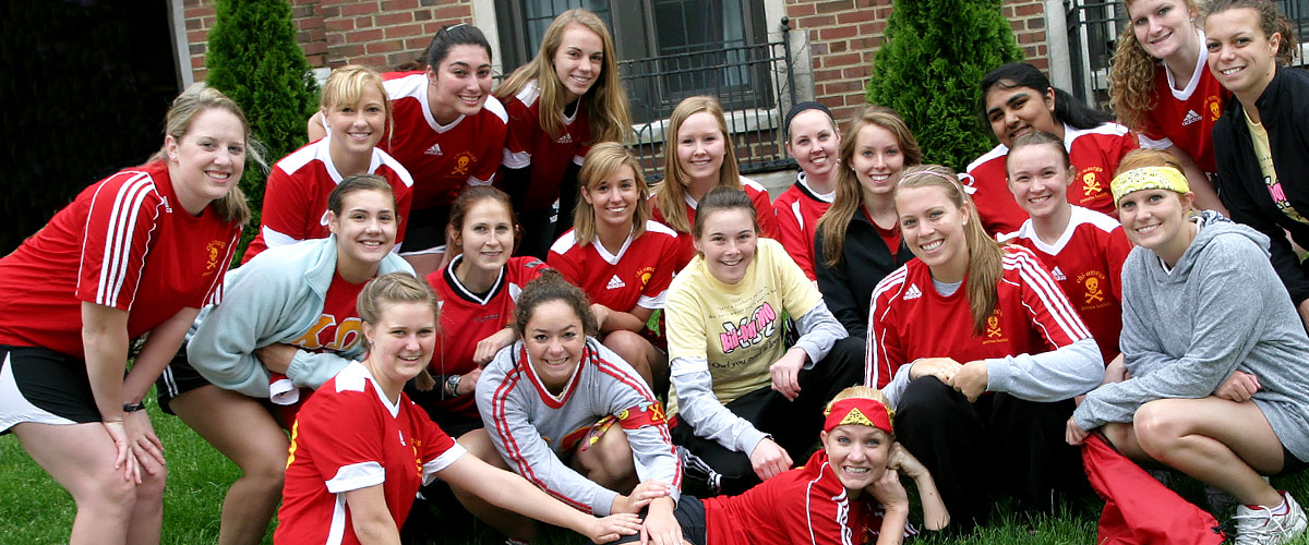 arge group of more than 20 sorority sisters pose in front of their sorority house. 