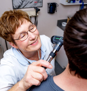 A nurse examines a student in the Health Services office.