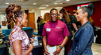 Female students smiles talking to another male student