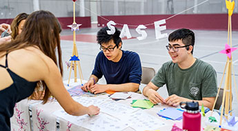 smiling students at display table