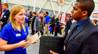 !Female recruiter talks to male student