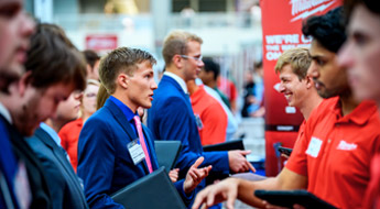 A line of students speak to a line of employers at the Career Fair.