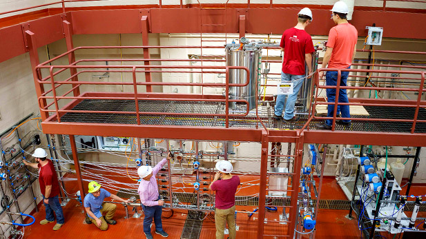 Students in hard hats working in high bay laboratory.