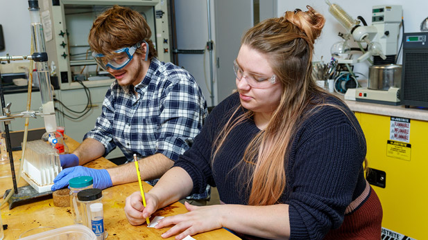 Male and female students working in a chemistry lab