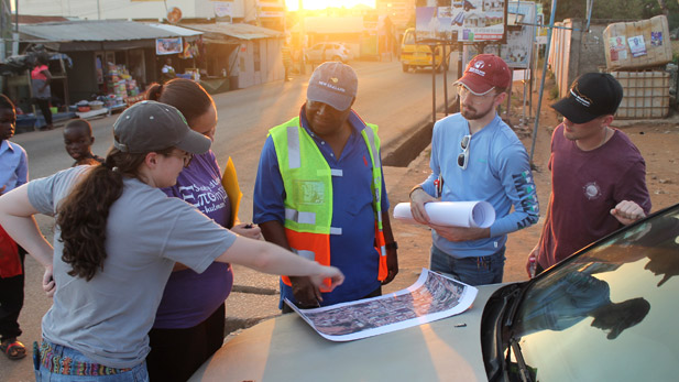 Civil engineering students reviewing plans on street in Ghana