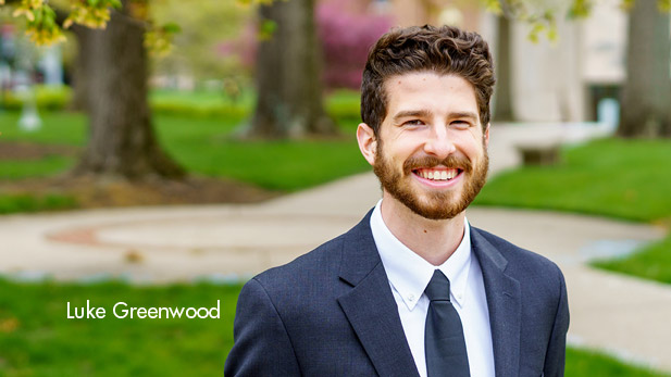 Luke Greenwood smiling outside on campus.