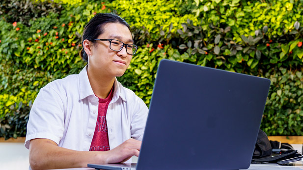 Jackson Shen sitting at a computer.