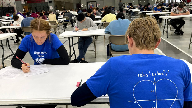 Students work on math problems at a table.