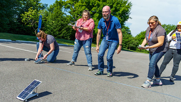 A group of teachers work on an activity outdoors at Rose-Hulman's PRISM program.