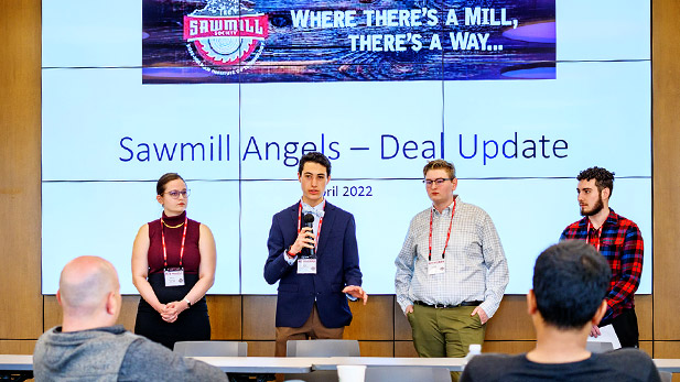 A group of individuals stand before the crowd at the Sawmill Society weekend event at Rose-Hulman.