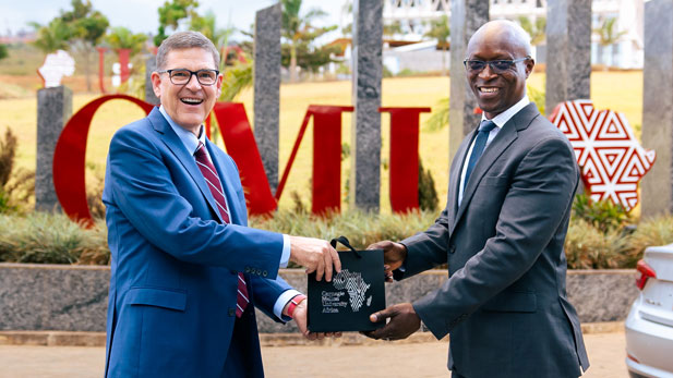 Conrad Tucker and Rick Stamper jointly holding print materials from Carnegie Mellon University Africa