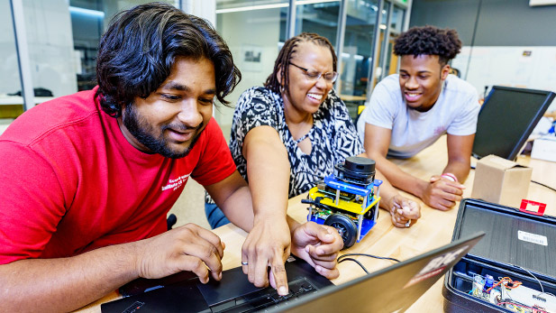 Carlotta Berry works with students at a computer.