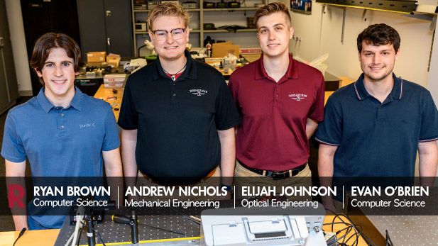 Ryan Brown, Andrew Nichols, Elijah Johnson, and Evan O’Brien (pictured L-R) pose in front of optical devices.