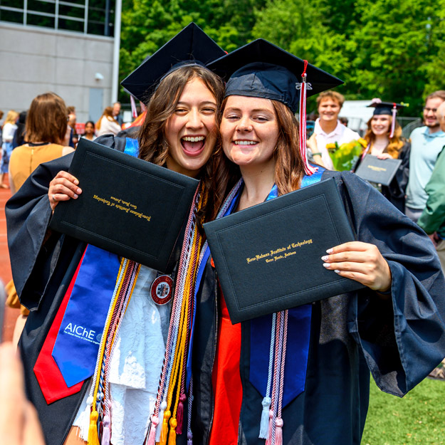 Graduates celebrate as red and white confetti falls.