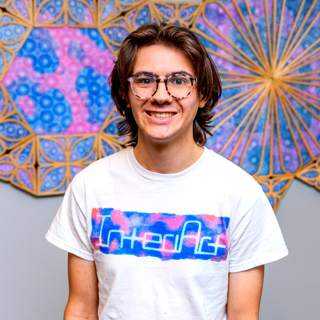 Connor Tasik is smiling at new art installation in Moench Hall.