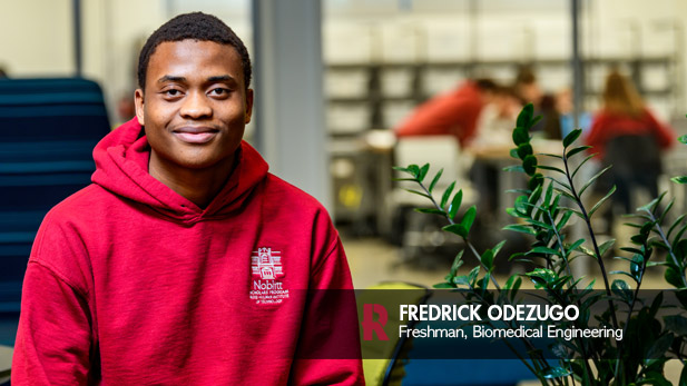Fredrick Odezugo wearing a Noblitt Scholars Program Sweatshirt in the Fowler Academic Building.