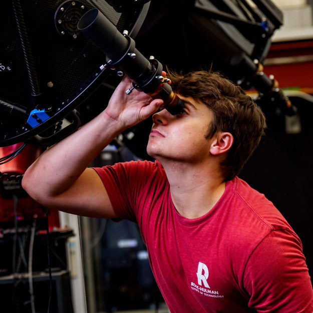 Male student looking into an Oakley Observatory telescope.
