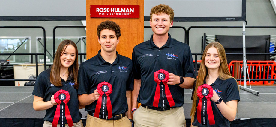 Four students with red award ribbons wearing PneumaNode polos.