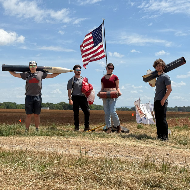Rose Rocketry team members with their rocket.