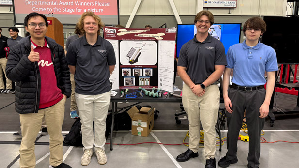 Four Rose-Hulman students—Colby Sanders, Ian Bowman, Tyler Cariola, and Trong Pham—standing beside their senior design project at Rose Show